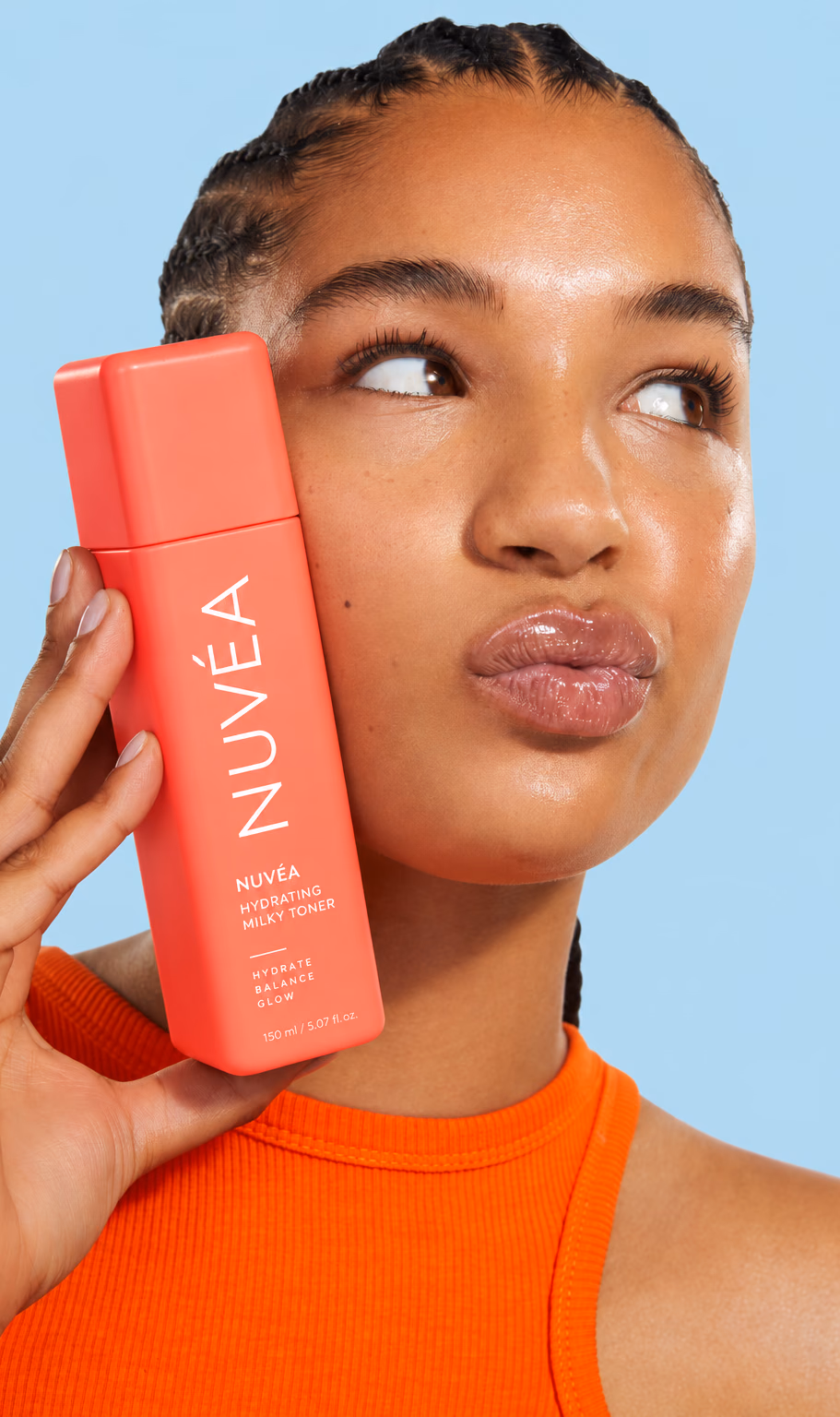 Woman holding a bottle of Nuvéa toner next to her face